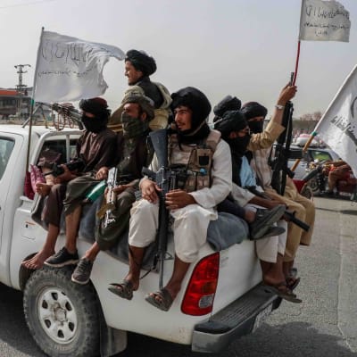 Joukko taliban-taistelijoita valkoisen avolava-auton lavalla 17. elokuuta 2021.