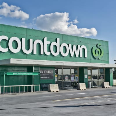 En mataffär med namnet Countdown i Auckland, Nya Zeeland. Ovanom huvudingången syns logon, vilket består av texten "Countdown" och ett äpple. Affärens väggar är gröna.