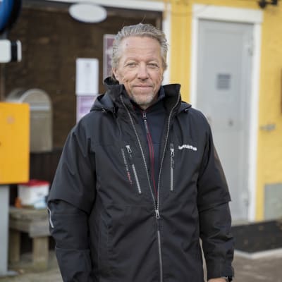 En person står utanför bybutiken.