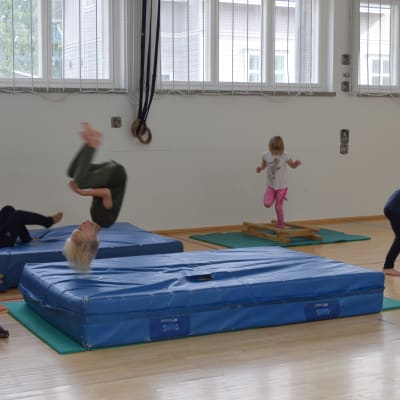 Barn som hoppar i gymnastiksal.
