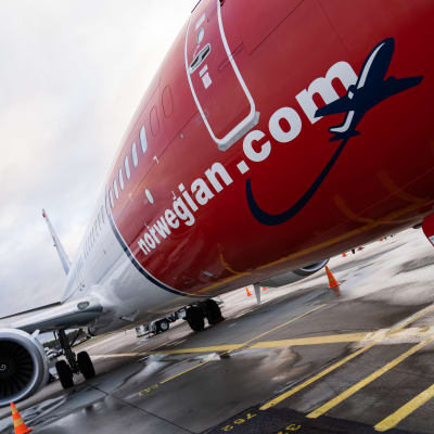 yleiskuva - Norwegian -halpalentoyhtiön kone lentokentällä odottamassa matkustajia.