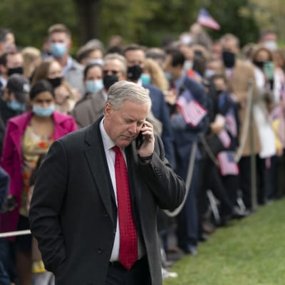 Mark Meadows pratar i telefon, i bakgrunden en folksamling.