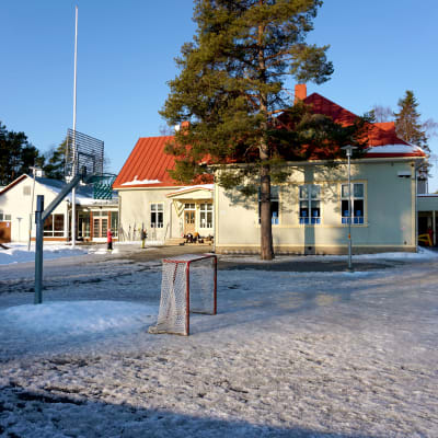 Skolgård med ishockeymål och basketkorg.
