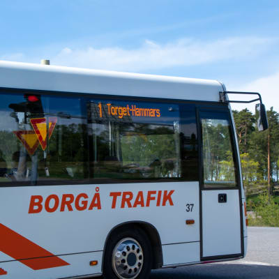 En vit buss med en Borgå trafik logo på sidan som står stilla. 
