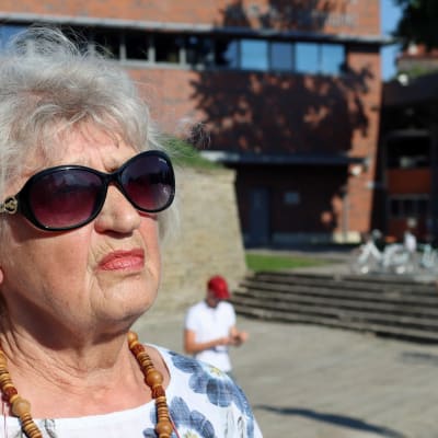 En äldre kvinna i solglasögon.