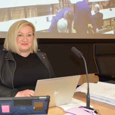 Tiina Isotalus sitter med en bärbar dator på ordförandeplats i Karleby stadsfullmäktige. 