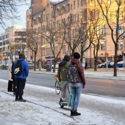 Folk står och väntar på en buss i Vasa centrum en dag i november.