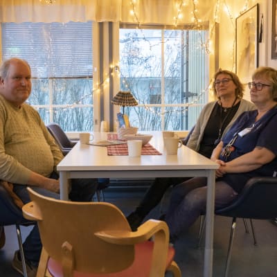 Tre personer vid ett bord med kaffmuggar. En man och två kvinnor.