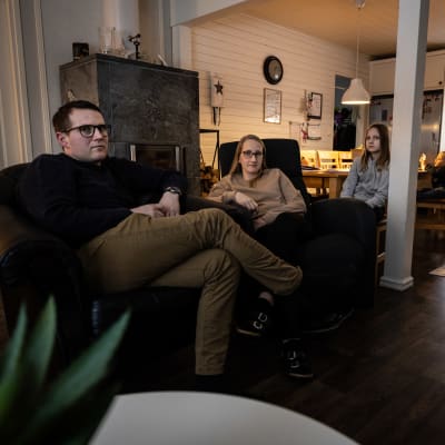 Tre personer sitter bredvid varandra i fåtöljer.