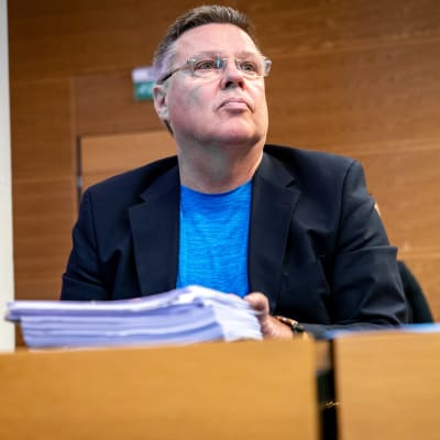 Jari Aarnio sitter bakom ett bord i Helsingfors tingsrätt.