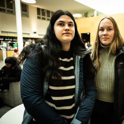 Porträttfoto av två kvinnor i en cafeteria