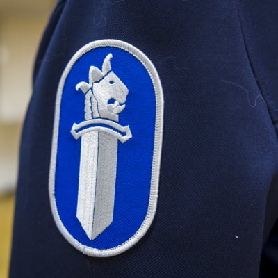 Polisens logo på en uniform.