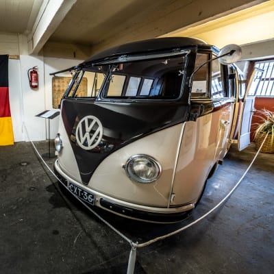 En gammal VW-minibuss, på väggen hänger en tysk flagga