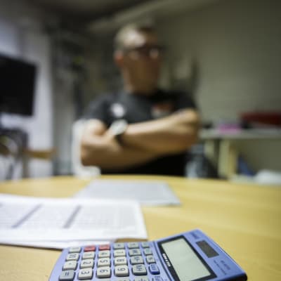 Taskulaskin ja papereita yrittäjän pöydällä.