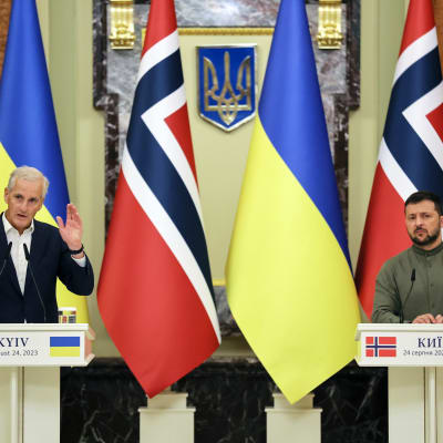 Pääministeri Jonas Gahr Støre ja presidentti Volodymyr Zelenskyi puhujanpöntöissä Ukrainan ja Norjan lippujen edessä.