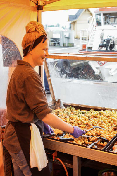 Mikaela Heikiö steker grönsaker i ett gatukök på Salutorget.