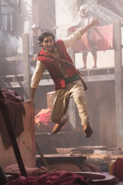 Aladdin (Mena Massoud) springer och tar ett språng i luften.