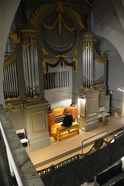 En man spelar på en stor kyrkorgel.