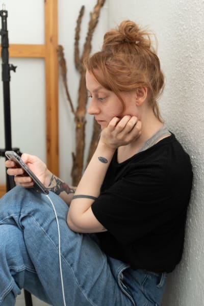 Hilla Kurki läser en artikel på sin telefon, 7.5 Vallgård