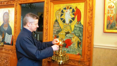 Pastor Mikael Sundkvist tänder ljus i Borgå ortodoxa kyrka