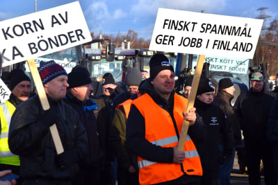 Bönder protesterar med plakat och traktorer i Vasa hamn.