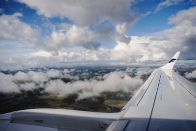 Vy från ett flygplan. Moln och terräng syns på bilden som tagits i Finland i september 2020.