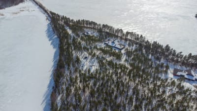 En fritidshus fotograferat i luften i ett vintrigt landskap.