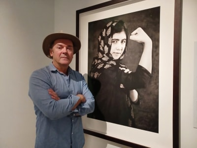 Den rikssvenska fotografen Albert Wiking framför hans porträtt av den kvinnliga pakistanska människorättsaktivisten Malala Yousafzai.