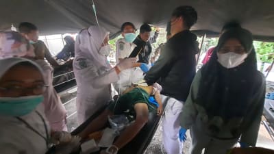 En patient vårdas i ett tält utanför ett sjukhus efter ett kraftigt jordskalv på Java.