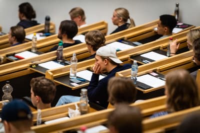Studerande sitter i en föreläsningssal.