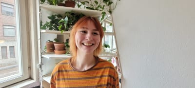 Kvinna med orange skjorta och rött hår.