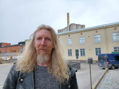Björn Wargh, utställningsmästare på Vasa stads museer. Han står framför Österbottens museum. Silorna som ska rivas finns i bakgrunden.