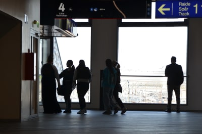 Siluetten av en grupp ungdomar som går genom en tågstation