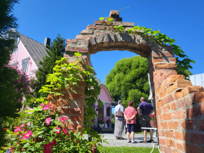 Människor på en gårdsplan sedda genom en murad port. 