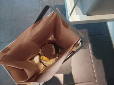 Keittiössä ruokajätteitä paperipussissa, joka on muovisessa jäteastiassa.