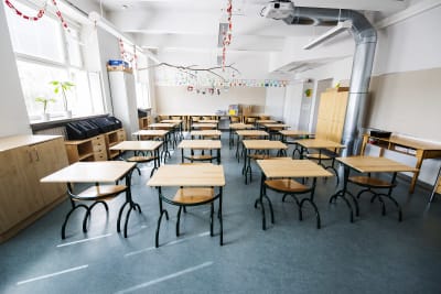 Klassrum med tomma pulpeter i en lågstadieskola. 
