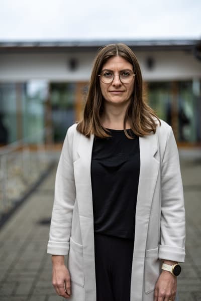 Porträttfoto av kvinna framför skolbyggnad