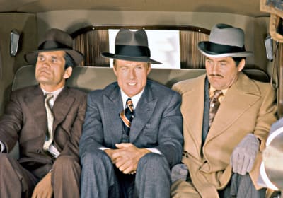 Robert Redford (keskellä) istuu auton takapenkillä elokuvassa Puhallus. Oikealla Robert Shaw, vasemmalla Charles Dierkop.