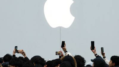 Människor fotar med telefoner en stor Apple-logo.