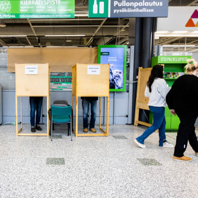 Äänestäjiä äänestämässä vaalikopissa Espoossa Olarin Prisman ennakkoäänestyspaikassa.