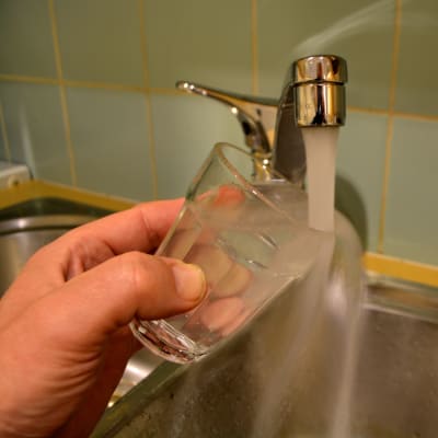 vatten som rinner från kran till dricksglas