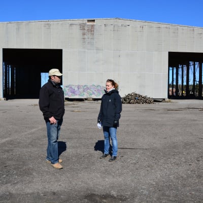 Båtföretagare Johan Hammarström och markanvändningsingenjör Annika Birell framför en gammal hall som nu ska bli båthall.