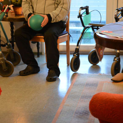 Äldre man deltar i sittgymnastik