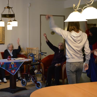 Närvårdarstuderande håller sittgymnastik för äldre på boendet Carl & Carolina i Vasa