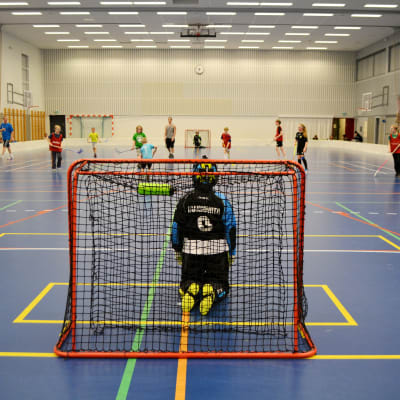 Barn spelar innebandy.