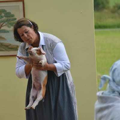 Janine Smeds håller upp en gris.