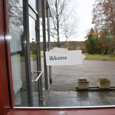Lappar med fisnka ord finns uppklistrade på olika håll i flyktincentralen. Fönster heter ikkuna på finska.