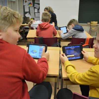 Eleverna Viktor och Hnery håller i pekplattor.