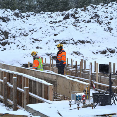 byggarbetare jobbar ut i vit vinter