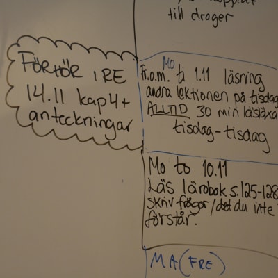 Anvisningar om läxor skrivna på tavla i skola.